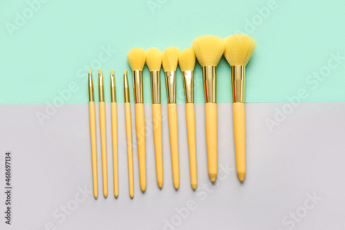Different beautiful makeup brushes on color background © Pixel-Shot