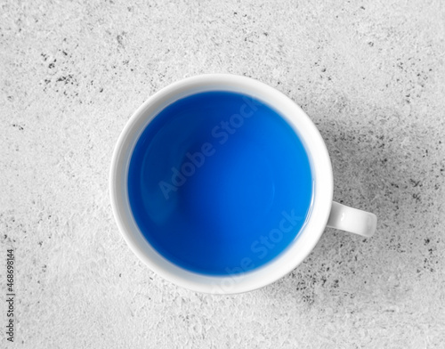 Cup of organic blue tea on white background, closeup