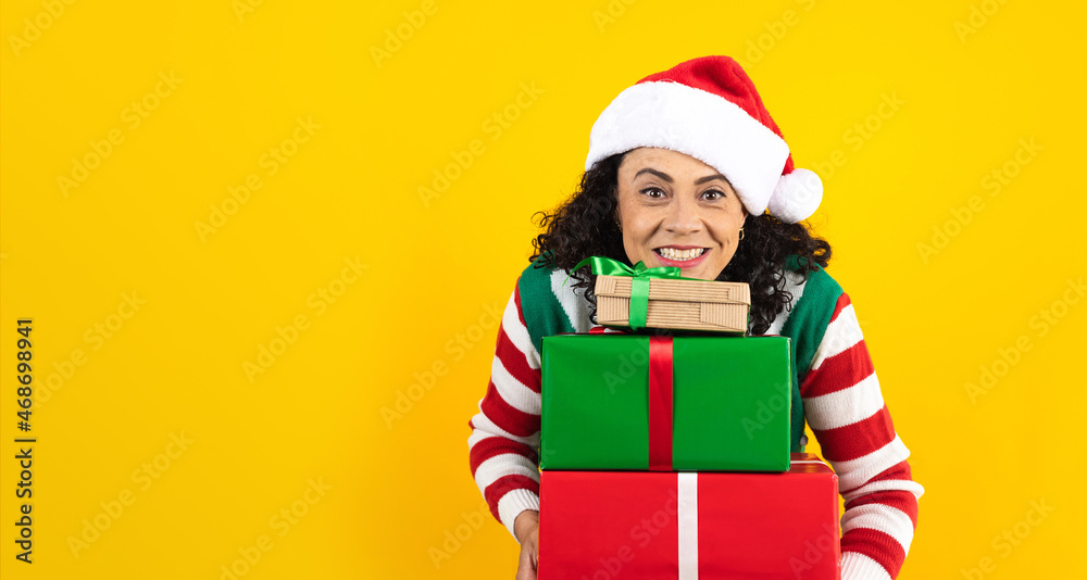 Portrait of Latin senior woman holding Christmas gift box on a yellow background in Mexico latin america Portrait of Latin senior woman holding Christmas gift box on a yellow background in Mexico latin america