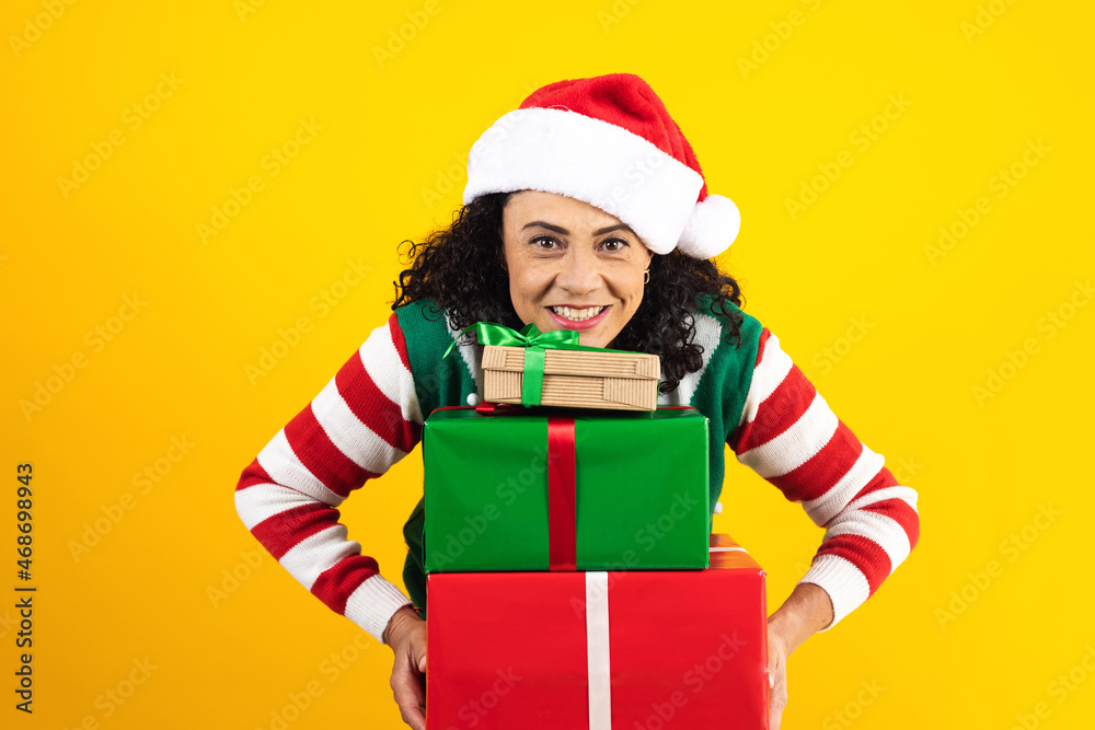 Portrait of Latin senior woman holding Christmas gift box on a yellow background in Mexico latin america Portrait of Latin senior woman holding Christmas gift box on a yellow background in Mexico latin america