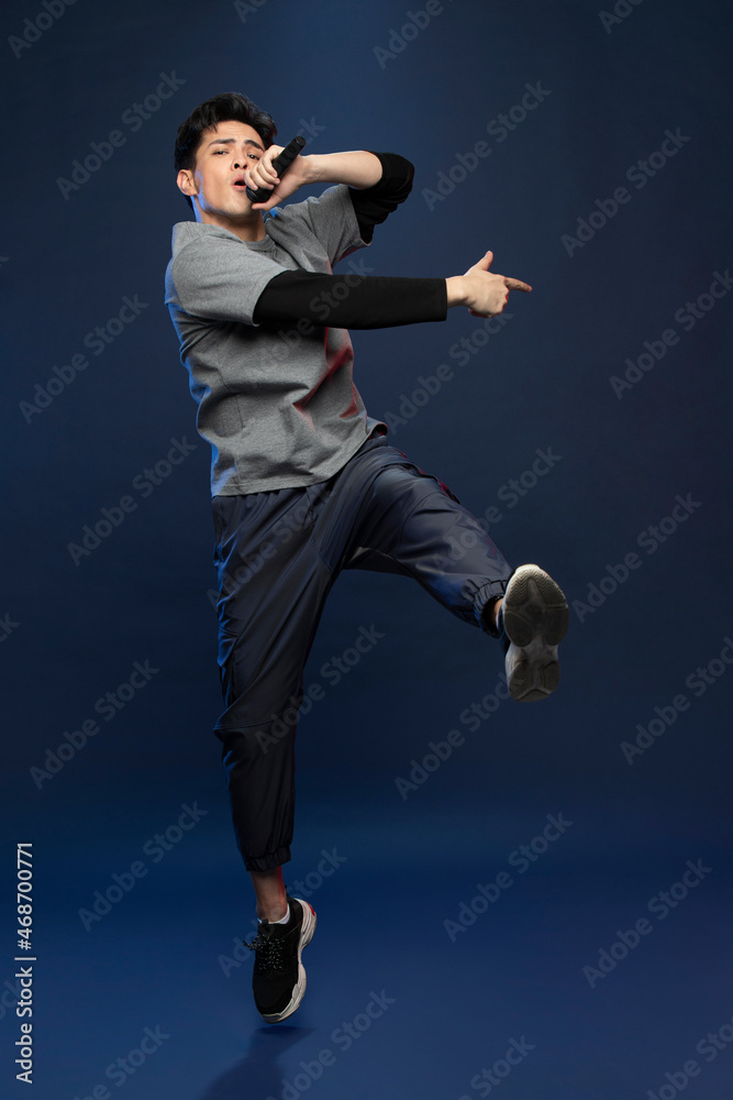 Studio shot of fashionable young Chinese man singing Studio shot of fashionable young Chinese man singing