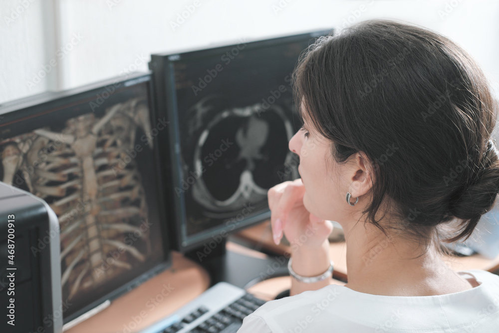 middle east woman doctor looking at monitor with chest bones computer