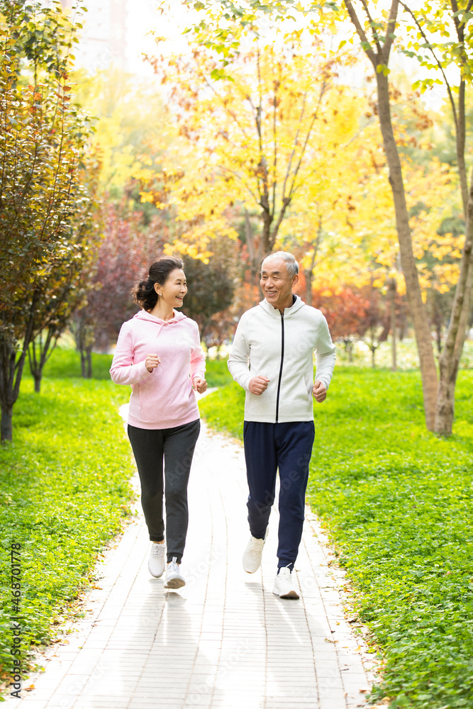 Happy senior Chinese couple running in the park Happy senior Chinese couple running in the park