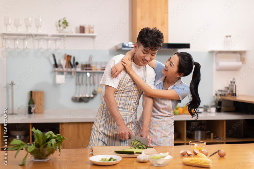 Happy young couple cooking in kitchen Happy young couple cooking in kitchen