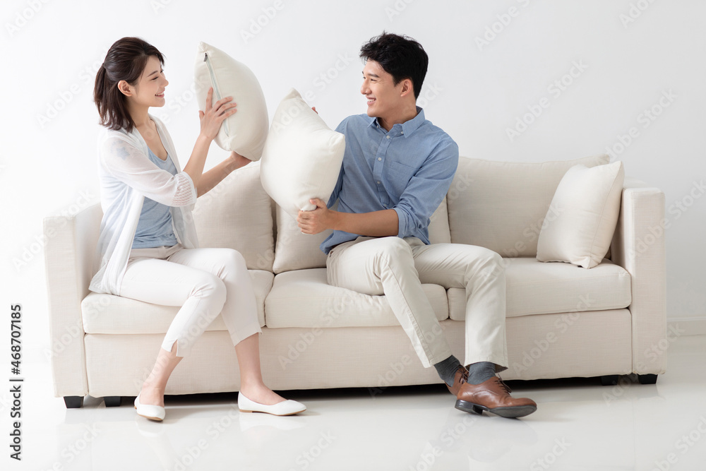 Cheerful young couple sitting on sofa Cheerful young couple sitting on sofa
