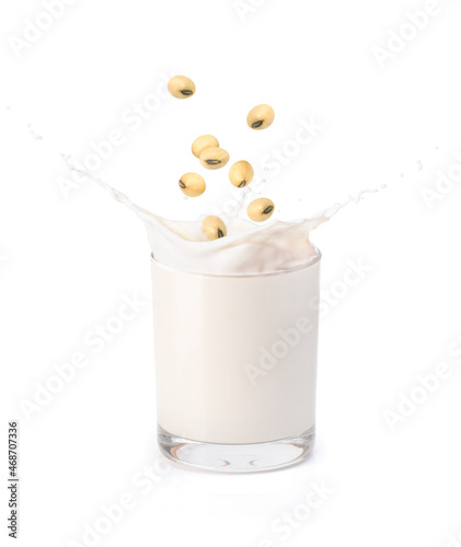 soy milk with splash and soybeans in sack bag isolated on white background.