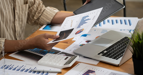 Close up hand of accountant working with computer and calculator for business and financial expense