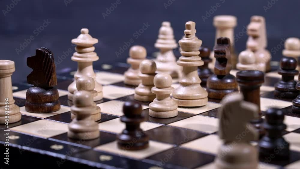 Slider shot of pieces on chessboard. Board intelligence game - wooden chess on dark background. Business solutions, challenge, sport, success strategy concept. Slider shot of pieces on chessboard. Board intelligence game - wooden chess on dark background. Business solutions, challenge, sport, success strategy concept.