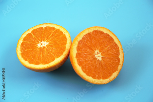 水色の背景に置かれた半分にカットされたオレンジ
