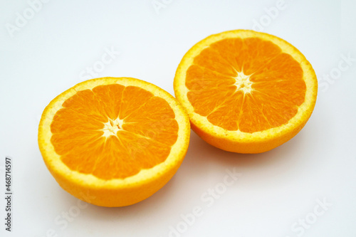 白い背景に置かれた半分にカットされたオレンジ