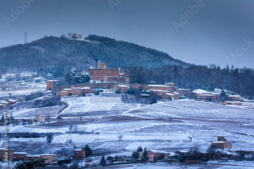 Snowed landscape of Beaujolais with vineyards and Montmelas castle, France