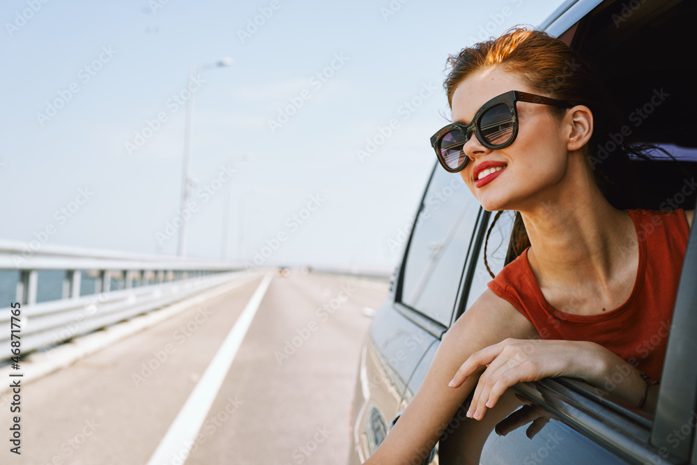 Naklejka premium a woman is driving in a car on the road and looking out of the window