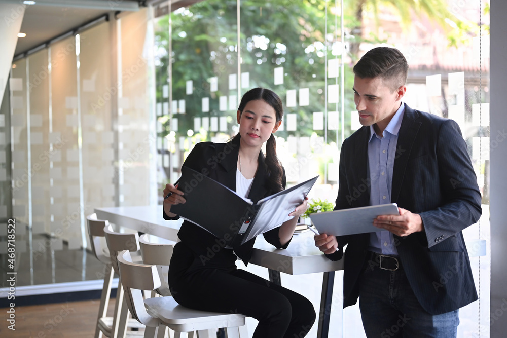 Handsome businessman discussing project planning with his colleague at modern office. Handsome businessman discussing project planning with his colleague at modern office.
