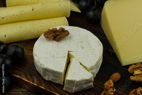 Camembert is a classic cow's milk cheese close-up with nuts and grapes. photo