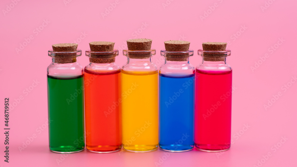 Liquid of different colors are poured into glass bottles with wooden corks Liquid of different colors are poured into glass bottles with wooden corks