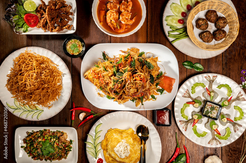 Top view on a delicious variety of Thai Traditional cuisine, Tasty Thai Food Mixed Selections Variety. A Delicious recipe from Asia ingredients on a dark wooden table.Thailand restaurant food menu