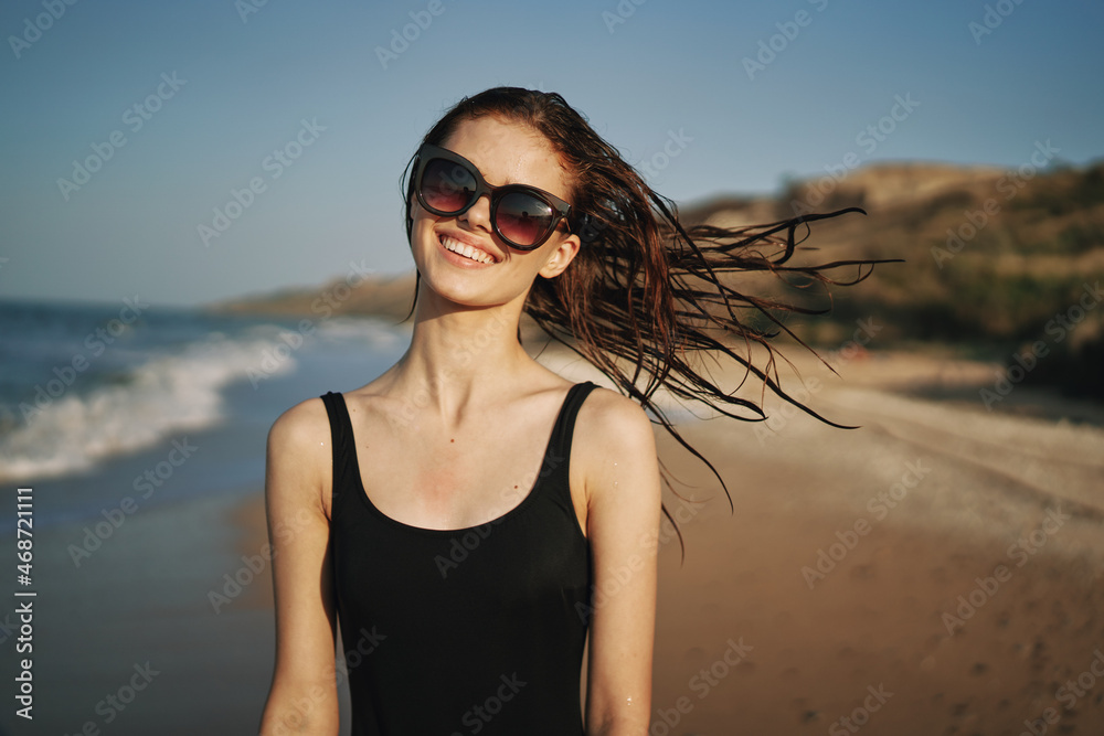 woman walks along the sandy shore in a black swimsuit sun tropics woman walks along the sandy shore in a black swimsuit sun tropics
