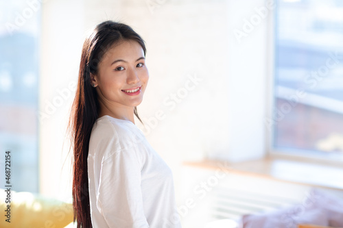 Portrait of smiling asian woman on apartment interior background. Free Download Portrait of smiling asian woman on apartment interior background. - GFXLoad
