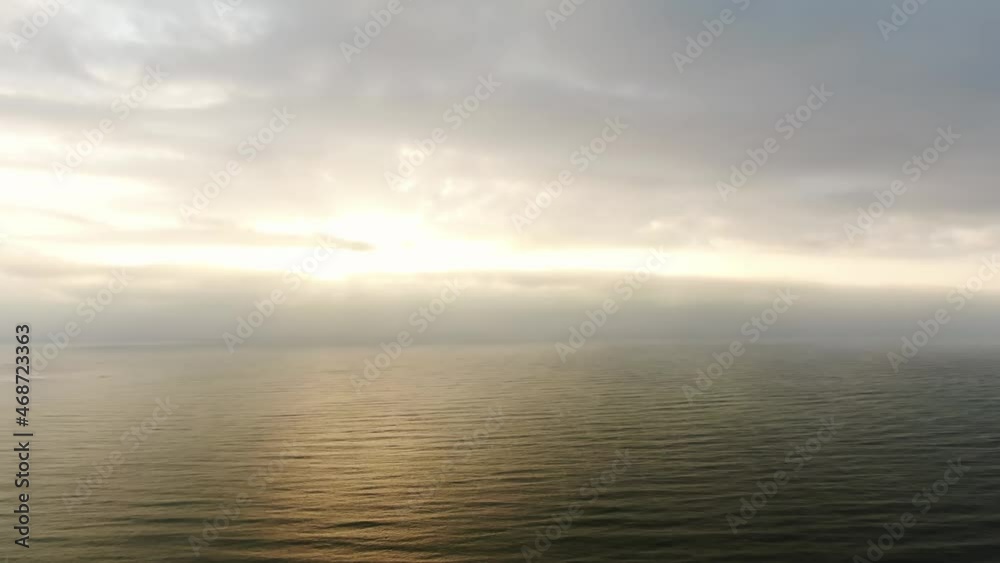 Water world. Aerial view of the sea surface during sunrise in the clouds on the horizon Water world. Aerial view of the sea surface during sunrise in the clouds on the horizon