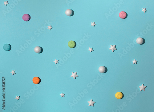 Christmas decorations  balls  stars and French Macarons creative composition against pastel blue background. Holidays pattern  winter joy  snowing theme. 