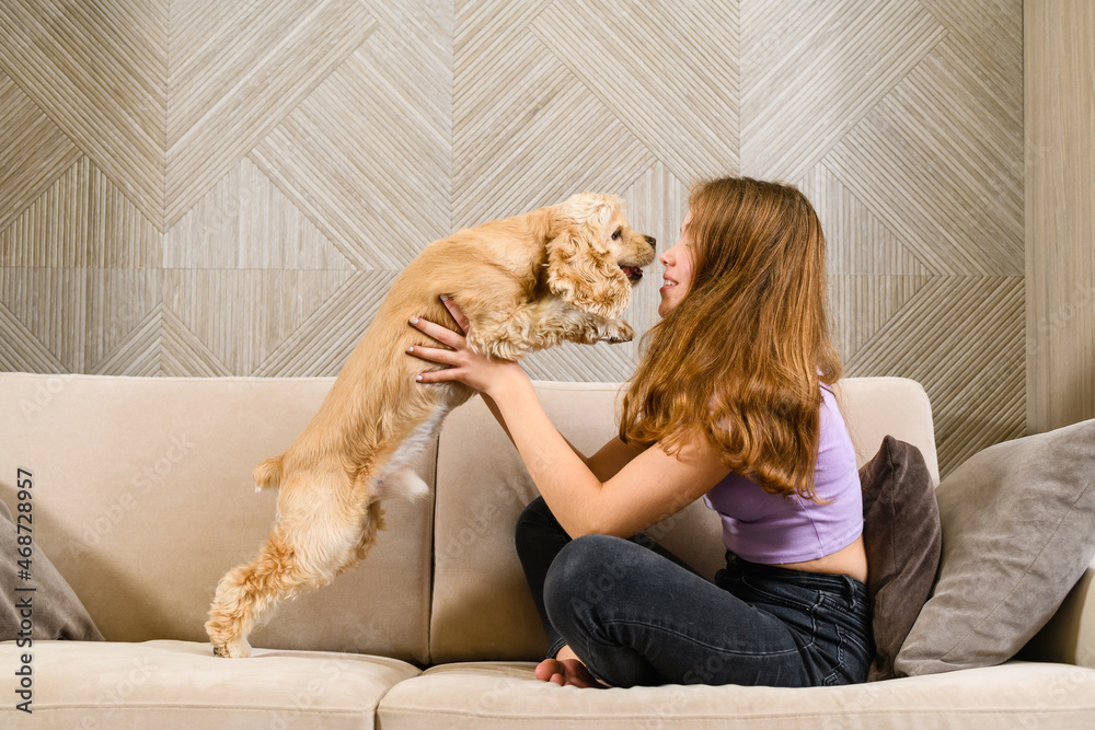 Girl hugging with her dog while sitting on couch