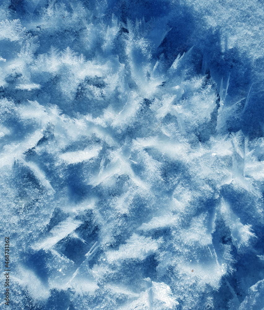 Fototapeta premium Snow crystals form beautiful snow pattern on frozen icy river. Snowflake background.