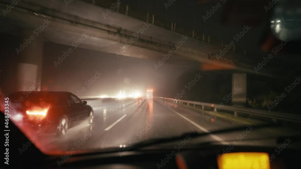 Driver point of view driving car at night in rain with wipers 4K