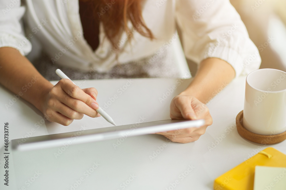 Cropped shot of Female assistant managing her tasks via portable tablet Cropped shot of Female assistant managing her tasks via portable tablet