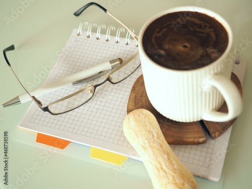 Filiżanka kawy na tarczy zegara i w biurze