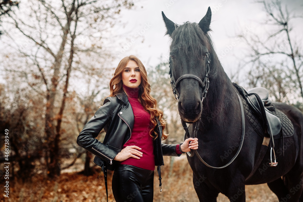 Obraz premium Beautiful young woman posing with a horse outdoors, close up