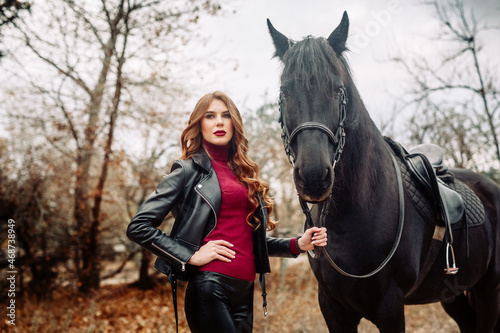 Beautiful young woman posing with a horse outdoors, close up