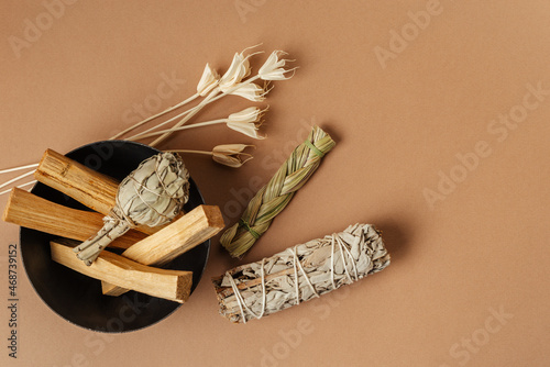 Set of incense for fumigation. Tied in a bunch of sprigs of white sage, sweetgrass, dried flowers, Palo Santo sticks. View from above. Organic holy tree incense from Latin America.