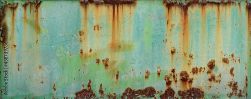 turquoise blue and green wall or surface of a fence of metal, with orange grooves from rust and irregular chipping - weathered texture for the background of a steampunk wallpaper photo