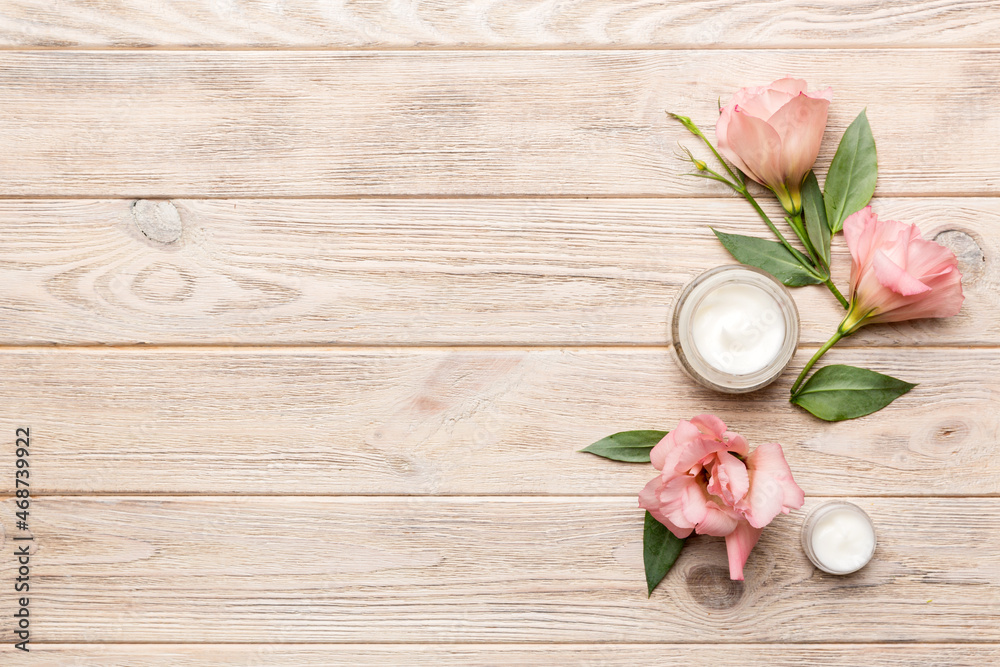 Composition with cosmetic products and beautiful roses on wooden background. Copy space, flat lay Composition with cosmetic products and beautiful roses on wooden background. Copy space, flat lay