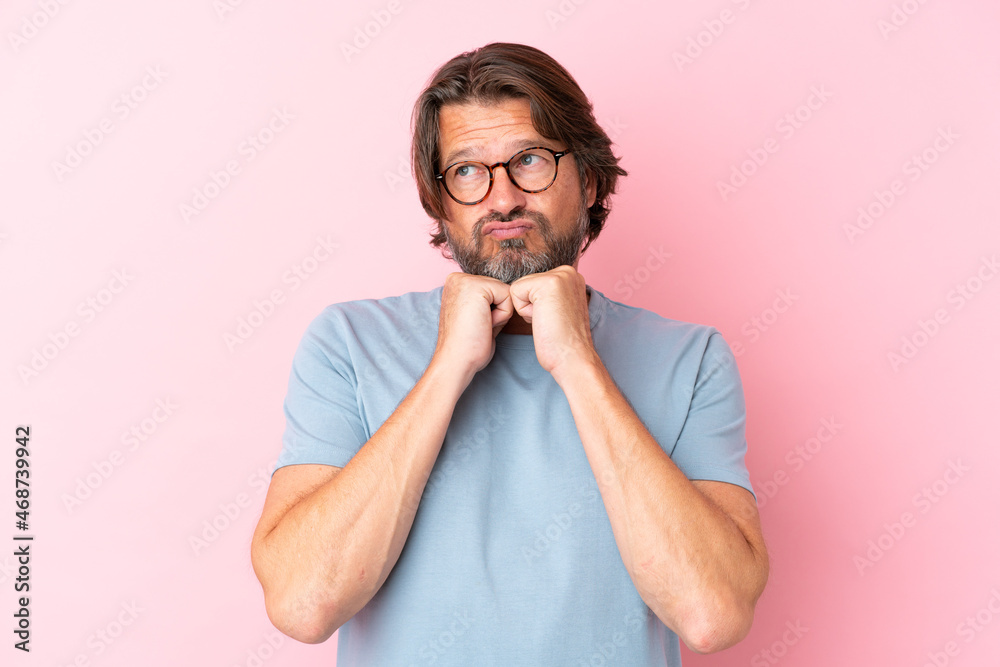 Senior dutch man isolated on pink background With glasses and tired Senior dutch man isolated on pink background With glasses and tired