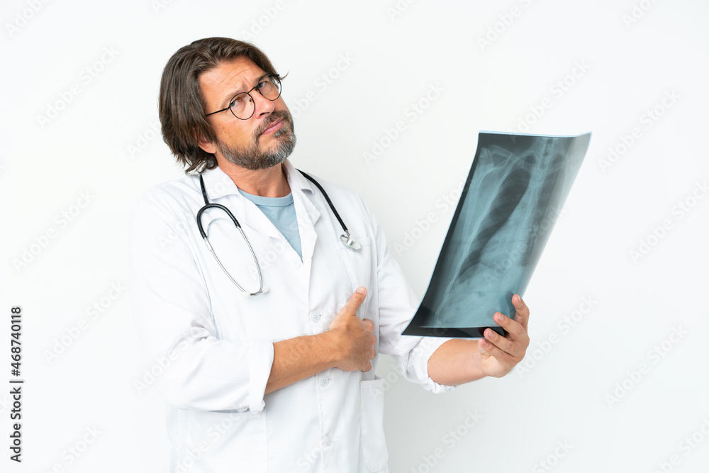 Senior dutch man isolated on white background wearing a doctor gown and holding a bone scan Senior dutch man isolated on white background wearing a doctor gown and holding a bone scan