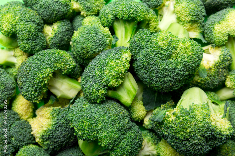 green fresh broccoli background close up on colored table. Vegetables for diet and healthy eating. Organic food green fresh broccoli background close up on colored table. Vegetables for diet and healthy eating. Organic food