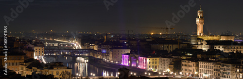 Cityscape of Florence at evening with Old Bridge and Palace of Townhall illuminated during Christmas period. Italy.