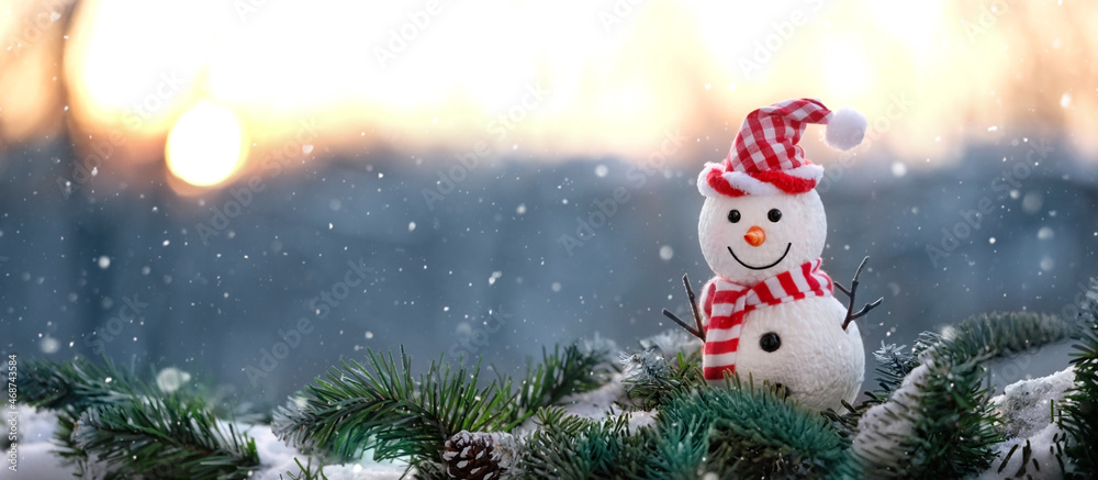 cute snowman toy on snowy fir tree, winter natural background. Christmas and New year holiday. winter festive season. banner. copy space cute snowman toy on snowy fir tree, winter natural background. Christmas and New year holiday. winter festive season. banner. copy space
