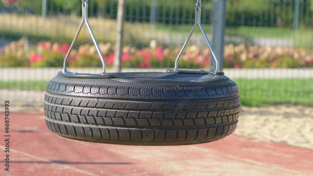 Empty swing made of the tire in the park in 4K slow motion 60fps