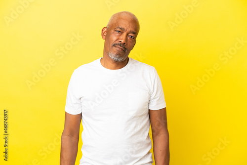 Cuban Senior isolated on yellow background with sad expression