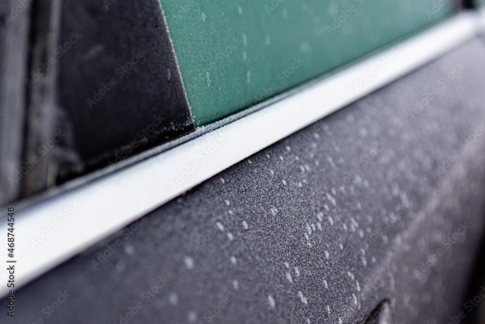 Frozen side window of the car.frozen car. the side of the car doors covered with frost. closeup.