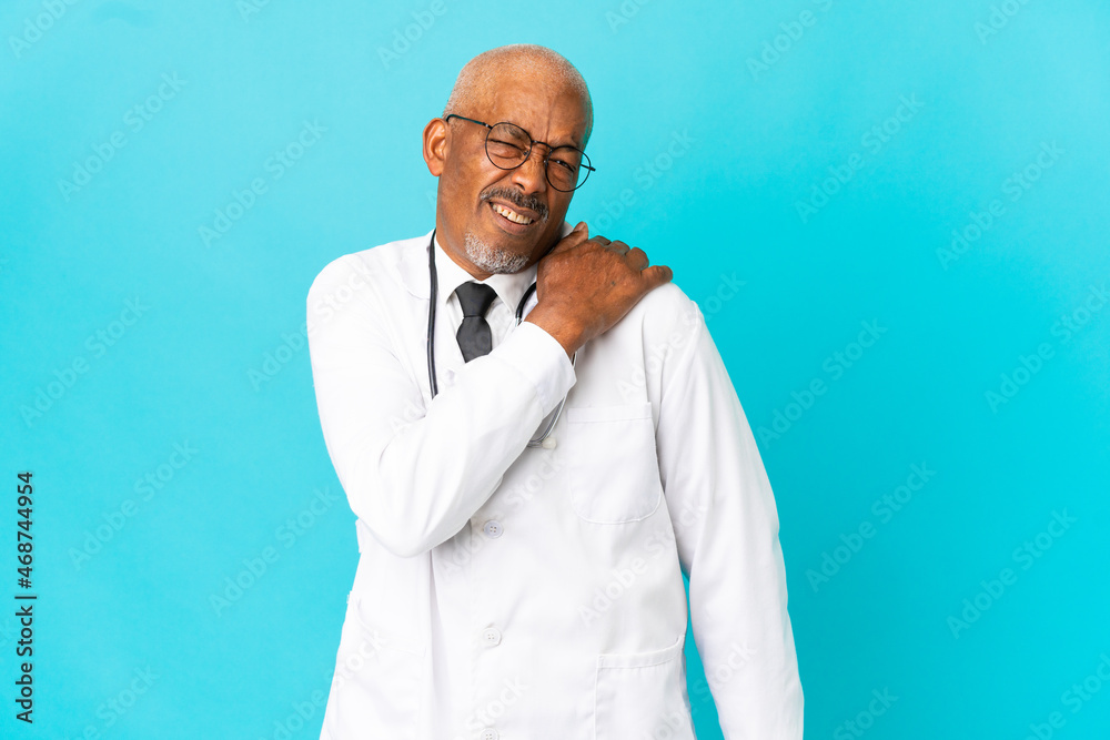 Senior doctor man isolated on blue background suffering from pain in shoulder for having made an effort