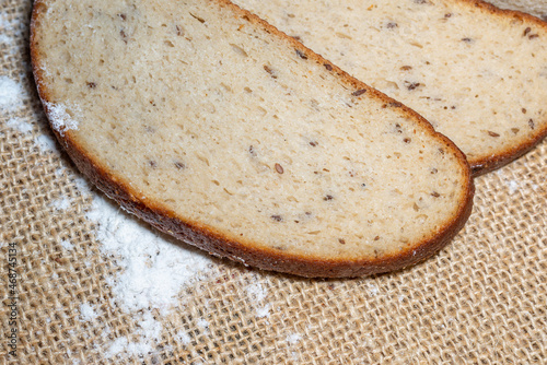 A fresh sliced bread on the beige linen canvas with flour.Closeup,selective focus.