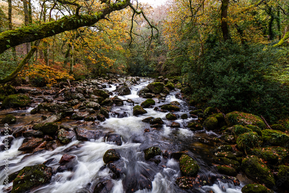 River tumbling over boulder - strewn rock at Dartmoor national park in Devon. River tumbling over boulder - strewn rock at Dartmoor national park in Devon.