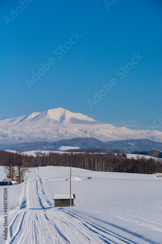 晴れた日の冬の丘陵地帯と雪山　大雪山  © kinpouge