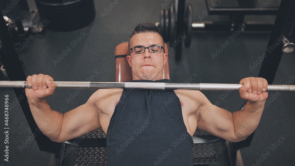 An Arab man shakes his chest with a barbell lying down.