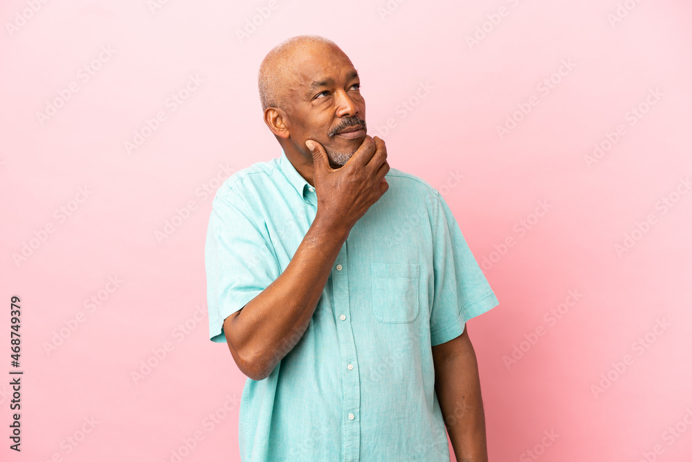 Cuban senior isolated on pink background having doubts Cuban senior isolated on pink background having doubts