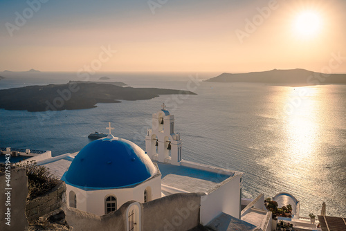 Famous traditional blue dome church at sunset in Santorini Island, Greece