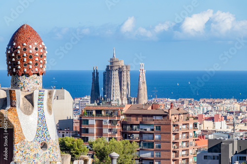 View of La Sagrada Familia of Gaudí and the Mediterranean sea from the famous Park Güell of the same architect Antoni Gaudí